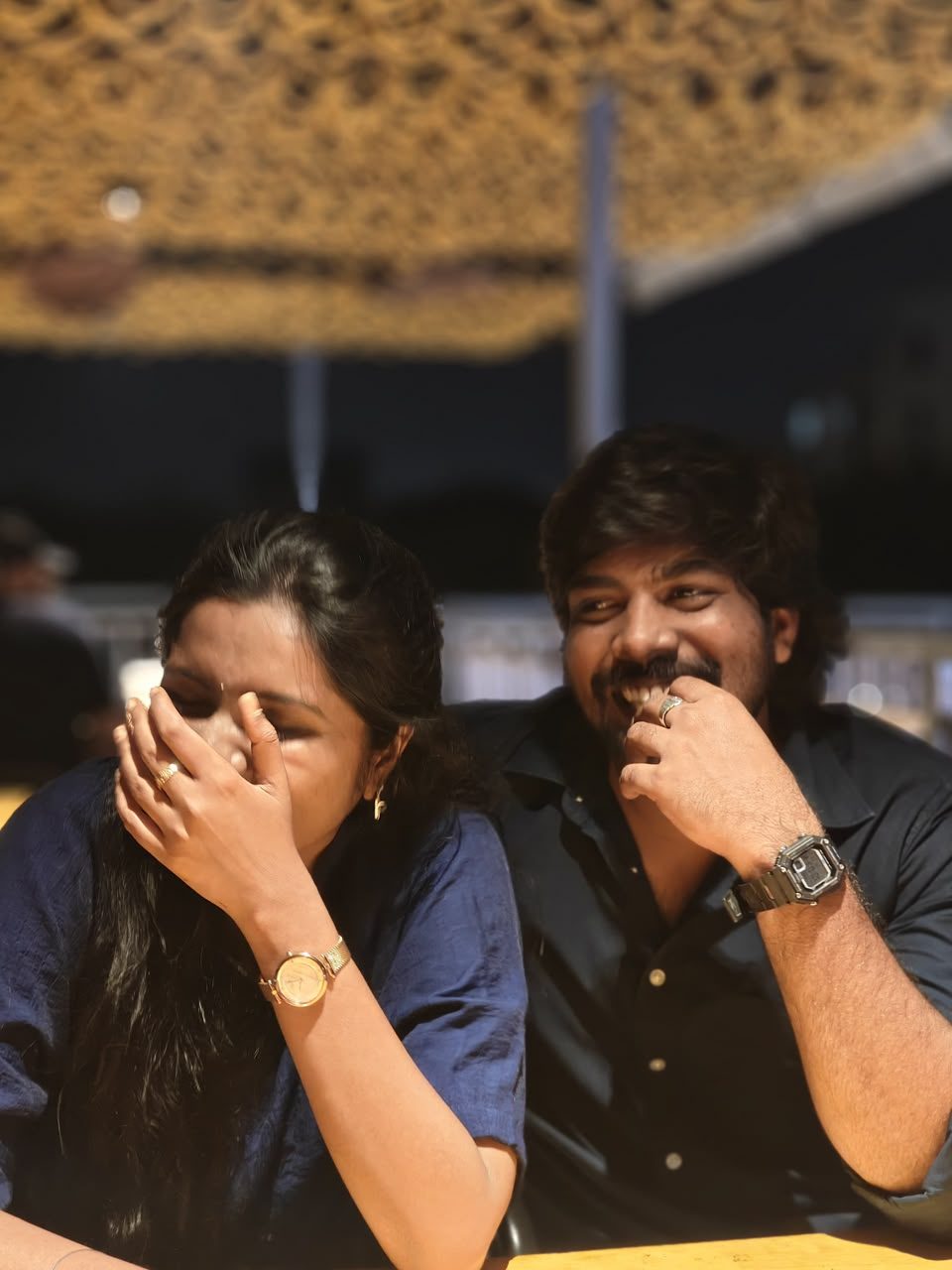 Teja and Lekha laughing together at dinner