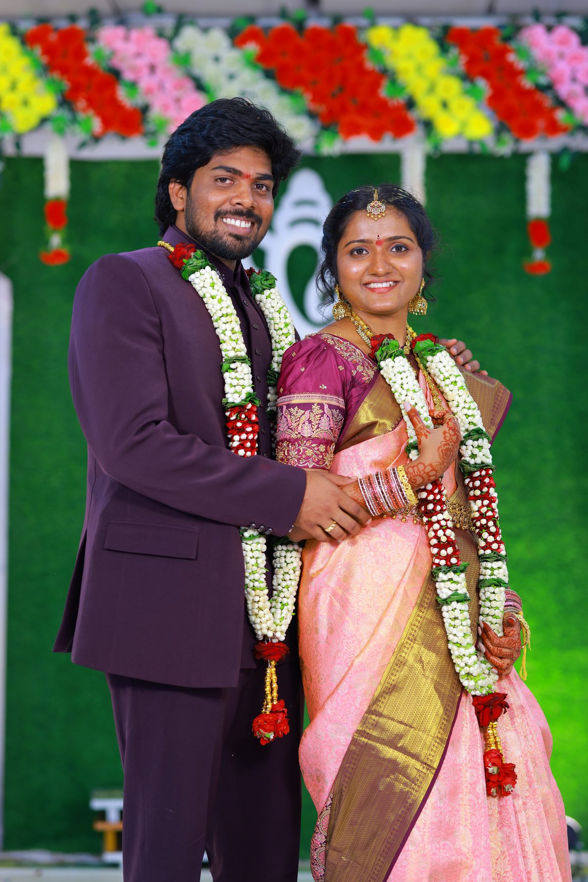 Teja and Lekha standing close together, smiling, in traditional engagement attire